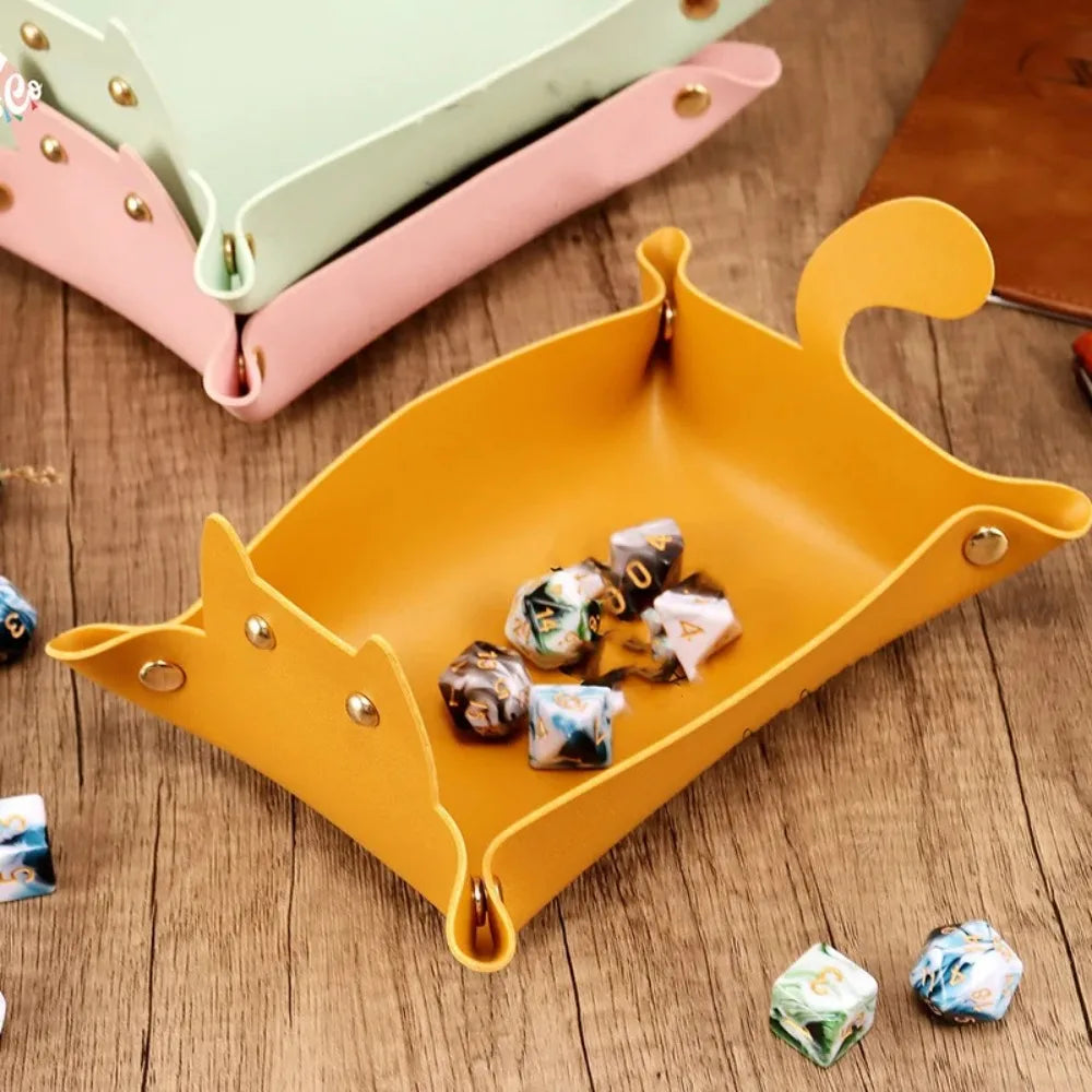 Yellow cat-shaped fold-flat tray holding polyhedral dice